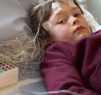 Child wearing traditional wired EEG headset